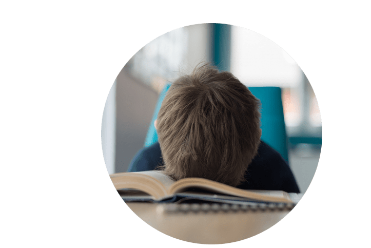 Junge lässt frustriert den Kopf in sein Buch senken